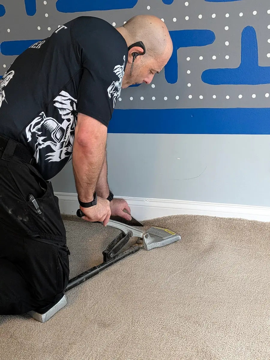 Wrinkled carpet ready for professional power stretching in a Charlotte NC home