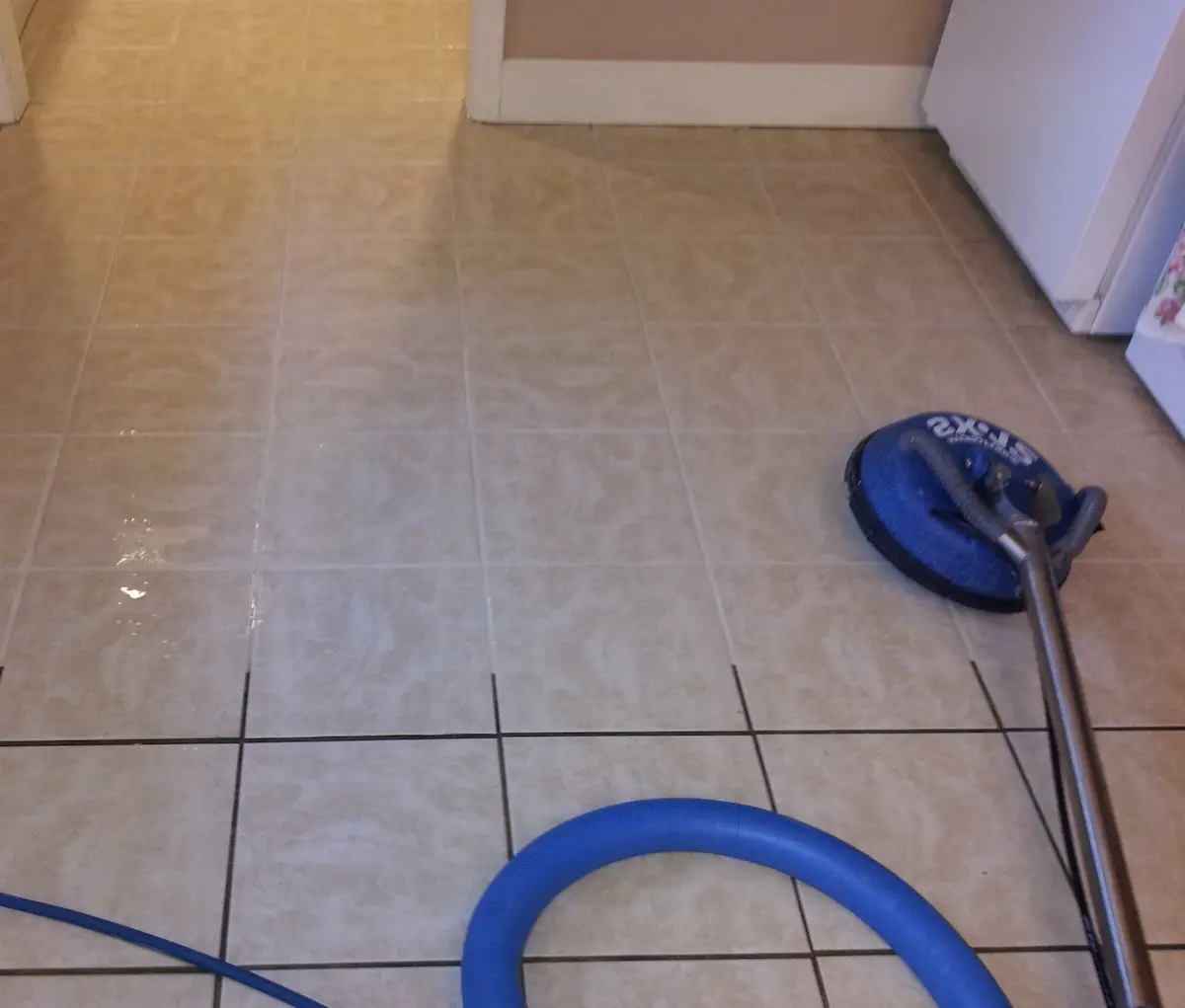 Technician deep cleaning tile and grout in a Charlotte home with a high-pressure rotary cleaning tool